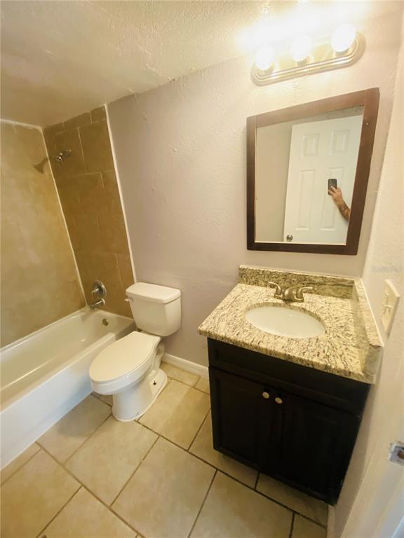 2771 L B McLeod Road, Unit A Orlando, FL 32805 - Photo 13 of 17 a bathroom with a granite countertop sink toilet and mirror