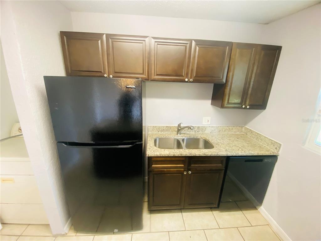 2771 L B McLeod Road, Unit A Orlando, FL 32805 - Photo 6 of 17 a close view of a sink and a refrigerator in a kitchen
