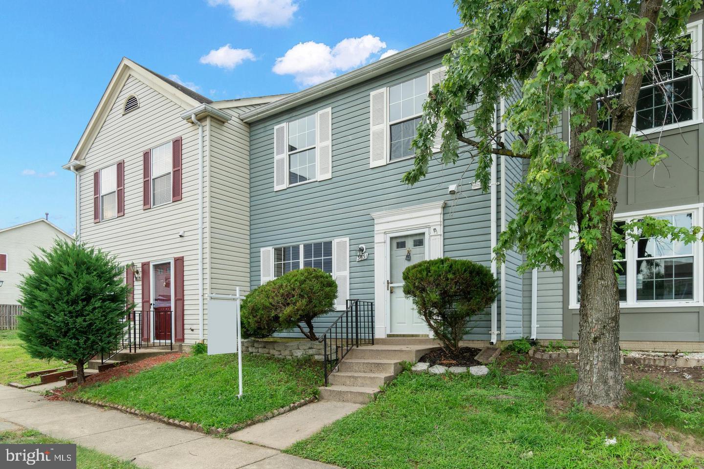 a front view of a house with garden and plants