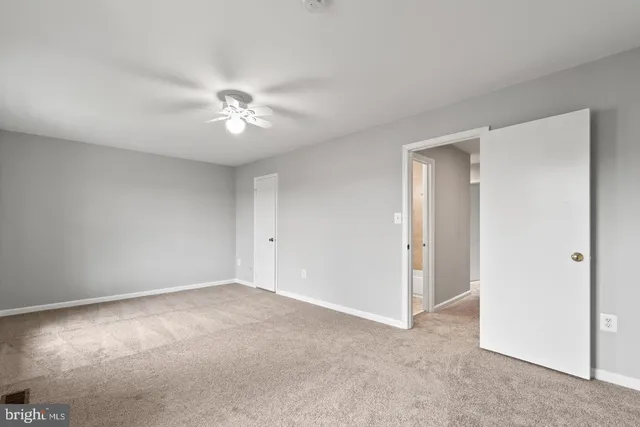 a view of a room with a ceiling fan and a window