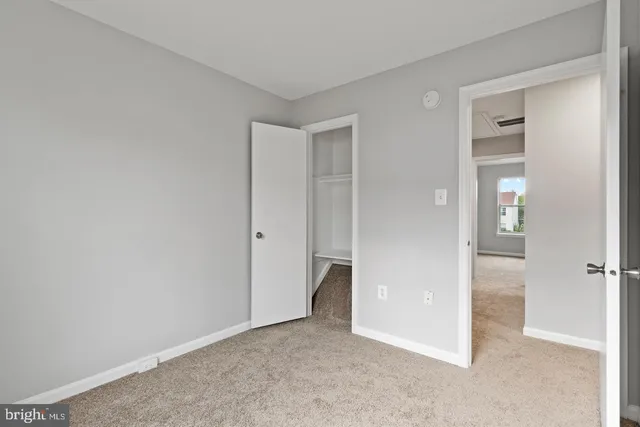 an empty room with closet and a bathroom