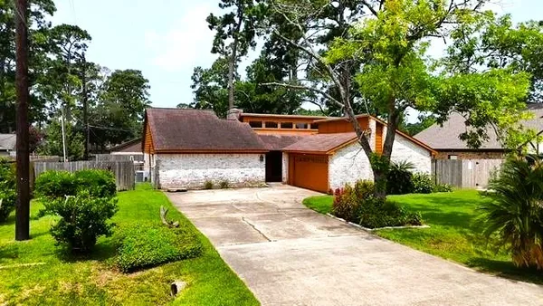 a front view of a house with a yard and potted plants