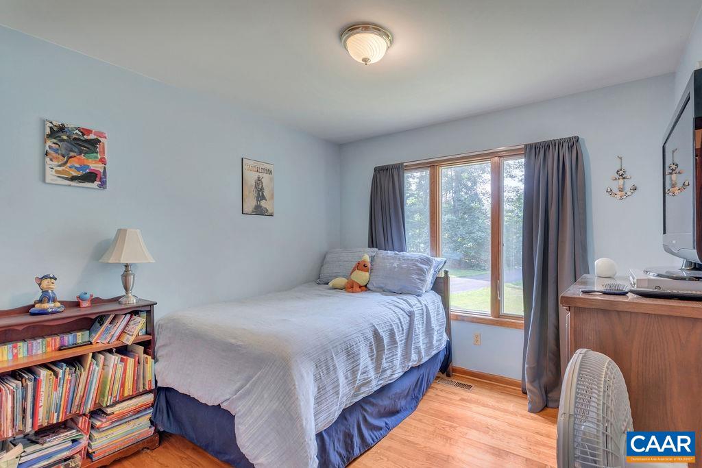6863 Amicus Road Ruckersville, VA 22968 - Photo 17 of 42 a bedroom with a bed and a book shelf