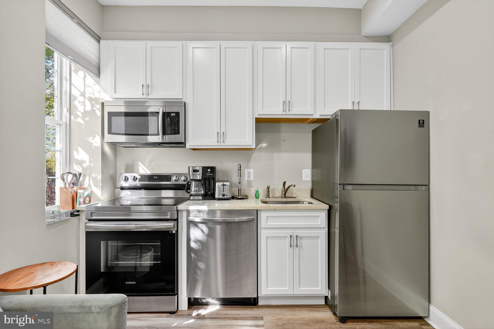 133 7th Street Southeast, Unit 10 Washington, DC 20003 - Photo 7 of 14 a kitchen with stainless steel appliances granite countertop a stove a refrigerator and a microwave
