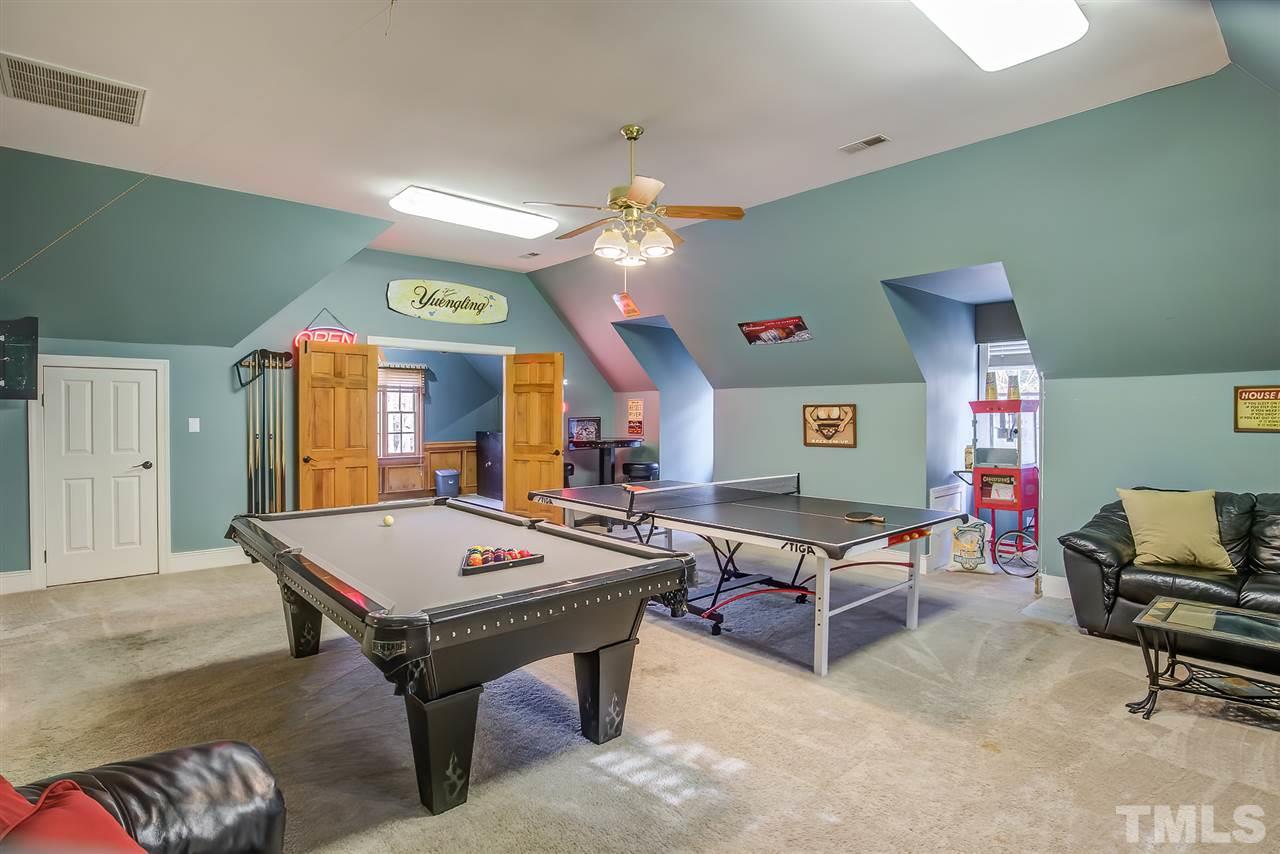 12129 Lockhart Lane Raleigh, NC 27614 - Photo 23 of 30 Large bonus room upstairs holds a full size pool table, full size ping pong table, room for darts, a popcorn machine, a pub table and chairs, a loveseat and coffee table, a wet bar and beverage fridge and another desk area and storage closet.