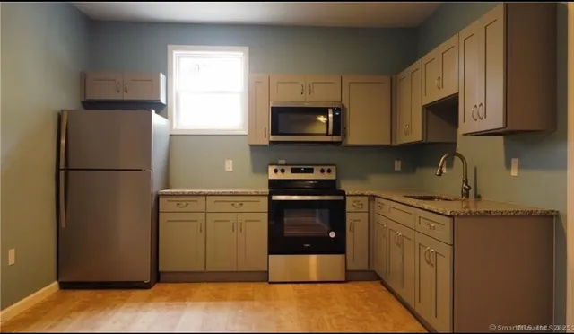 a kitchen with stainless steel appliances granite countertop a refrigerator stove a sink and dishwasher