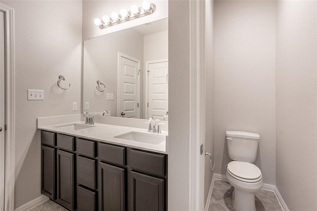 615 Stampede Road San Marcos, TX 78666 - Photo 9 of 26 Double vanity sinks and a private commode area provide functional design for daily routines.