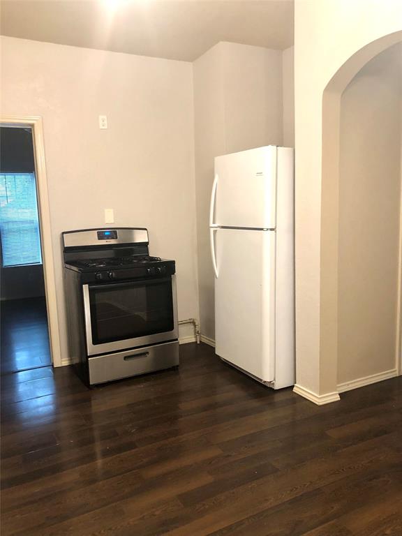 905 Isbell Road Fort Worth, TX 76114 - Photo 16 of 29 Kitchen with dark wood-type flooring, stainless steel gas stove, and white refrigerator