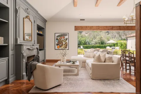 a living room with fireplace furniture and a large window