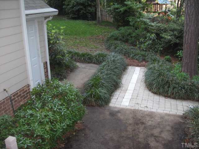2612 Diamondhitch Trail Raleigh, NC 27615 - Photo 17 of 25 The side ceramic tile patio and storage closet. Look at the bear grass!