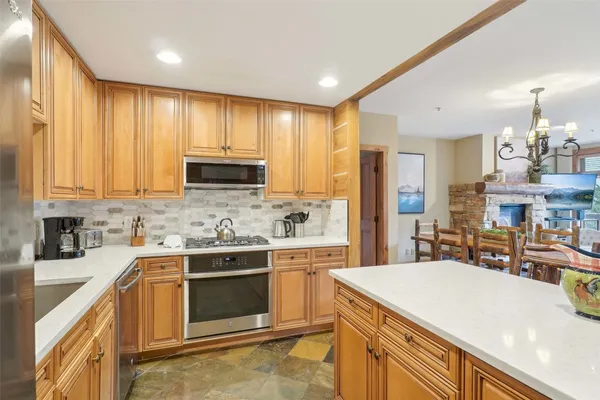 a kitchen with stainless steel appliances kitchen island granite countertop a sink and cabinets