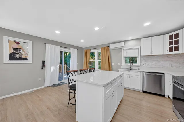 a large white kitchen with sink and cabinets