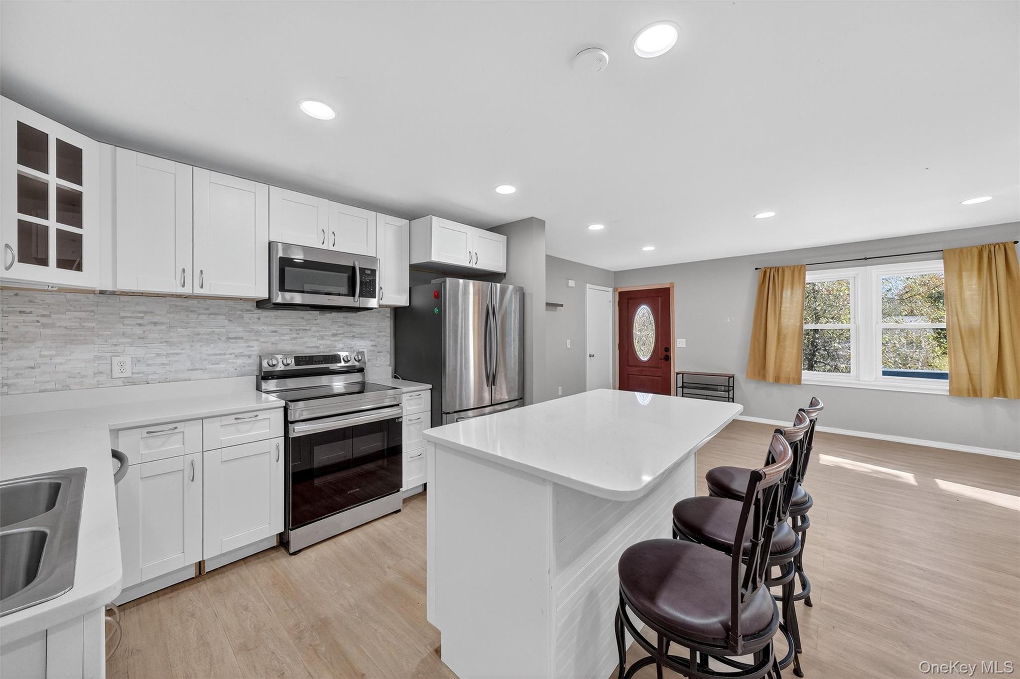 12 3rd Street Milton, NY 12547 - Photo 13 of 34 a kitchen with kitchen island a dining table chairs appliances and cabinets