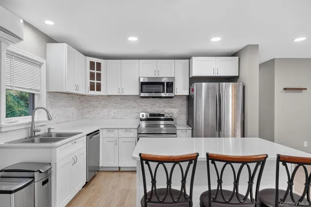 a kitchen with stainless steel appliances a dining table chairs microwave and sink