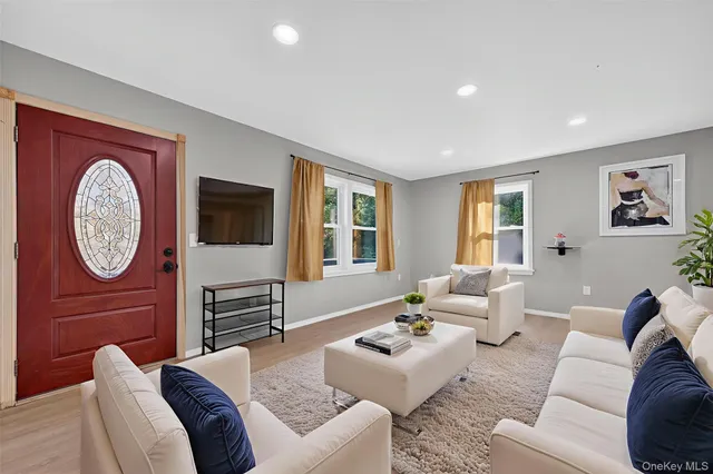 a living room with furniture a large window and a flat screen tv
