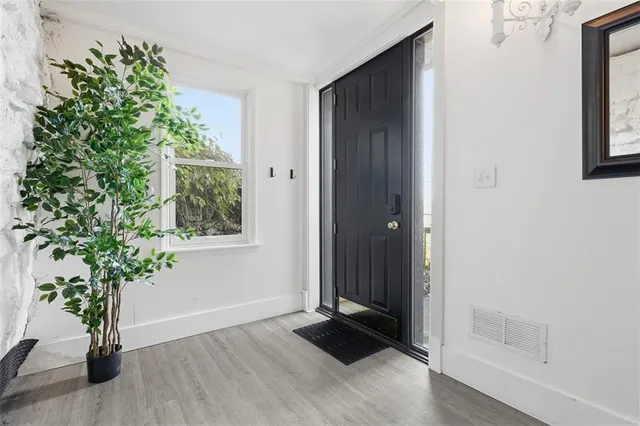 an empty room with wooden floor and a potted plant