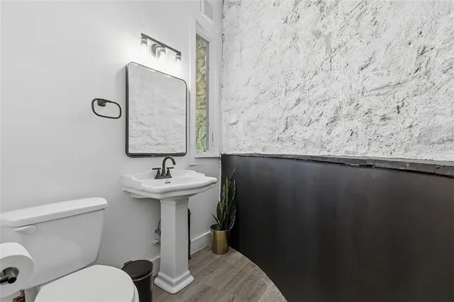 a bathroom with a sink a toilet and mirror