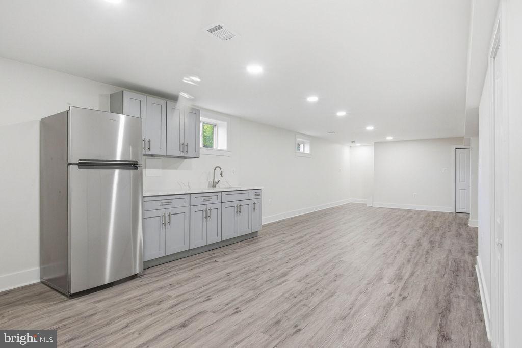 6620 Napoli Road Temple Hills, MD 20748 - Photo 25 of 38 a kitchen with a refrigerator a white cabinets and wooden floor