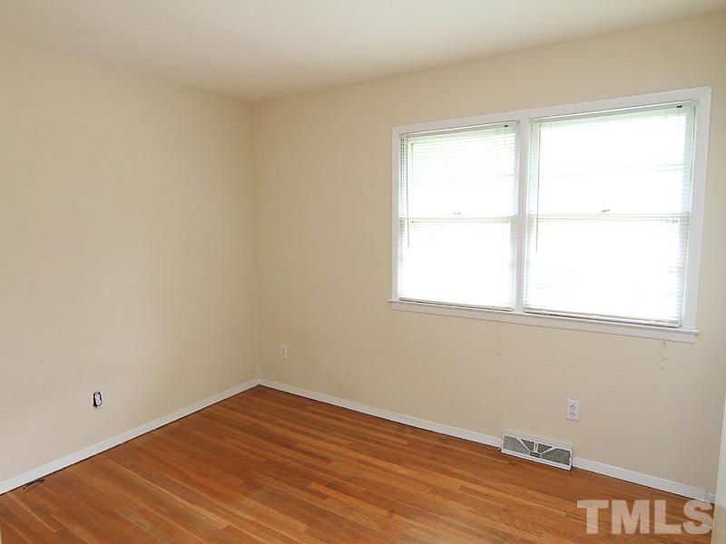 4609 Revere Road Durham, NC 27713 - Photo 7 of 12 an empty room with wooden floor and windows