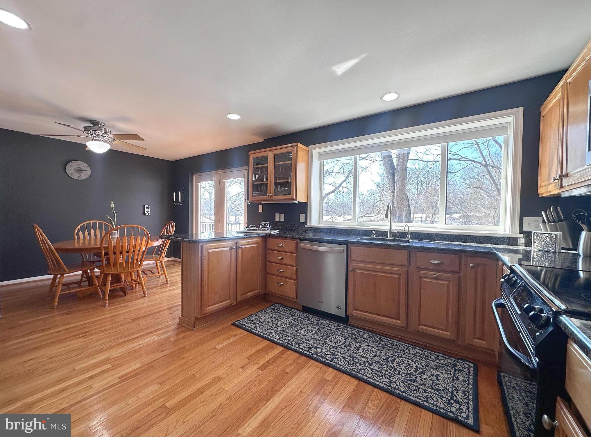 2158 Golf Course Drive Reston, VA 20191 - Photo 2 of 35 a kitchen with stainless steel appliances granite countertop wooden cabinets a dining table and chairs