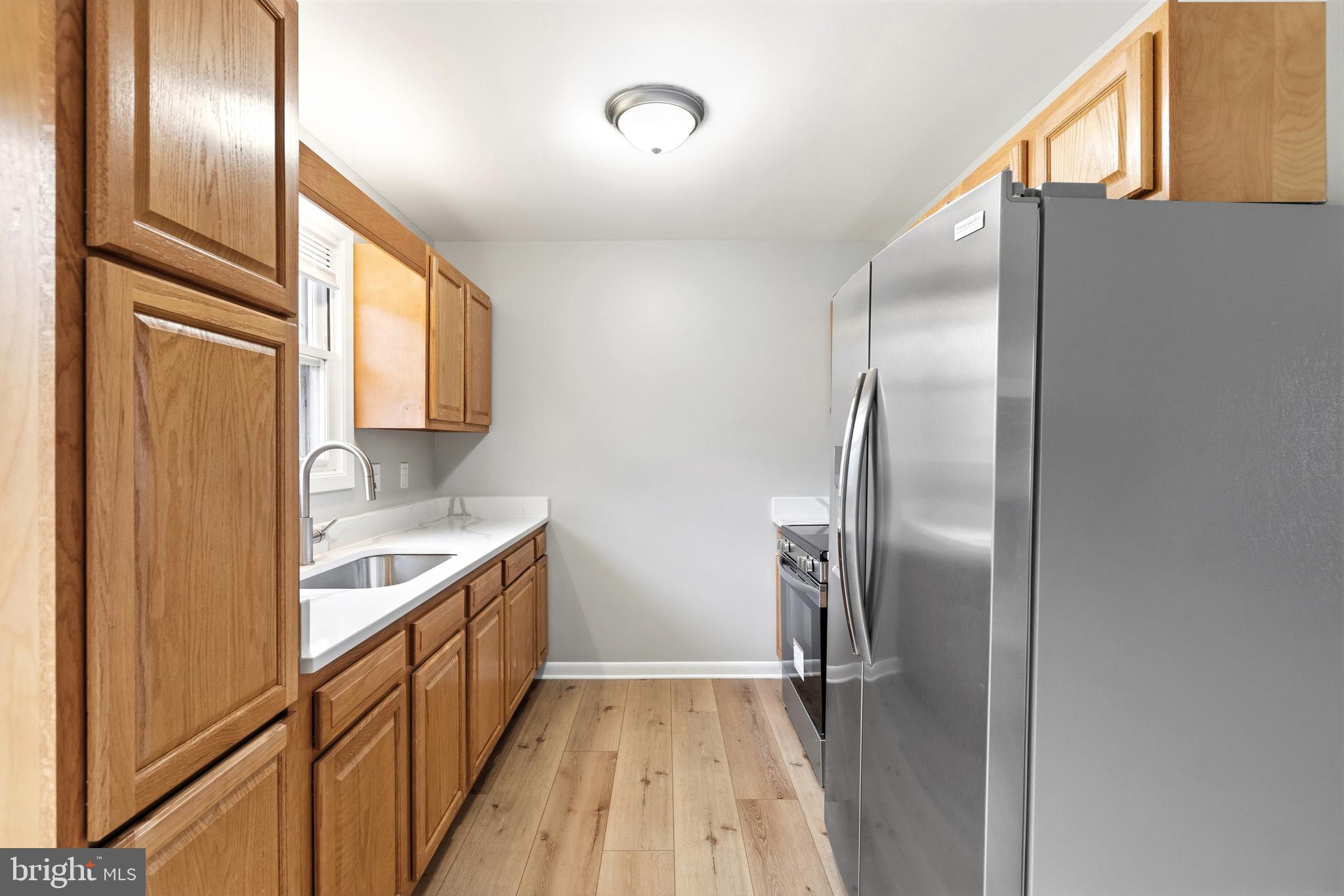 404 Weeping Willow Road Falling Waters, WV 25419 - Photo 9 of 24 a kitchen with stainless steel appliances granite countertop a refrigerator and a sink