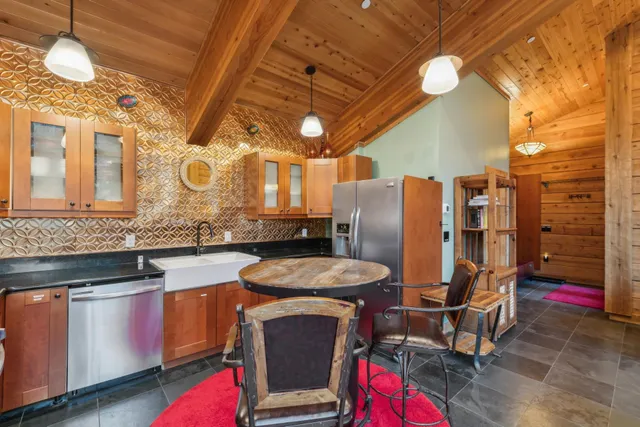 a kitchen with stainless steel appliances granite countertop a sink a stove and wooden floors