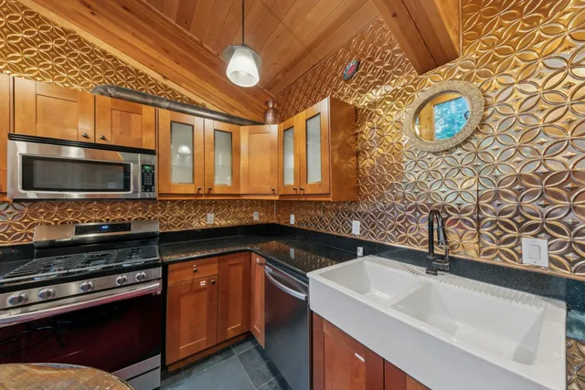 a kitchen with stainless steel appliances granite countertop a sink and a stove