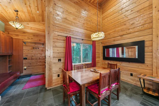 a view of a dining room with furniture a chandelier and window