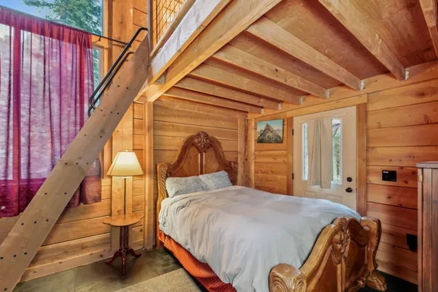 a bed sitting in a bedroom next to a window