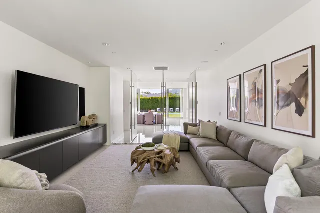 a living room with furniture a floor to ceiling window and potted plant
