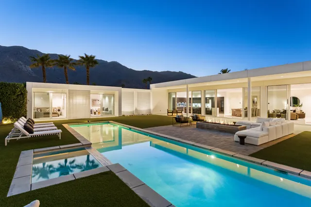 a view of a house with swimming pool and sitting area
