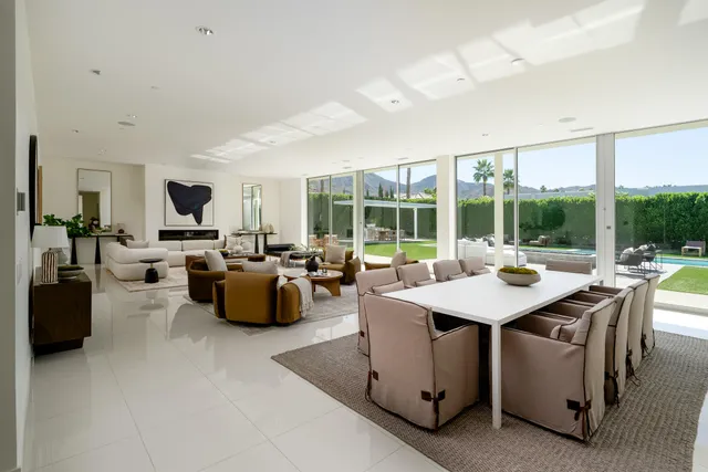 a dining room with furniture and a large window