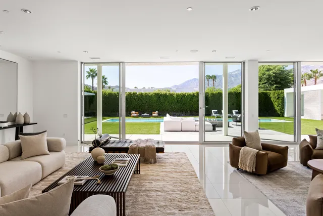 a room with stainless steel appliances kitchen island granite countertop a table chairs and a refrigerator