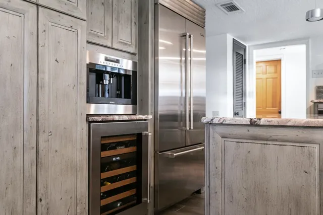 a kitchen with stainless steel appliances granite countertop a refrigerator and a sink
