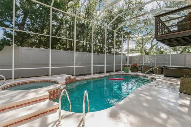 a view of swimming pool with chairs and wooden fence