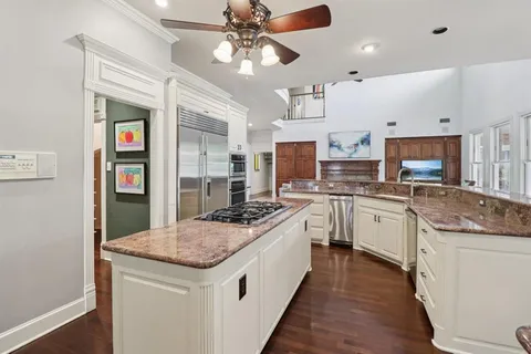 a kitchen with a stove sink and cabinets