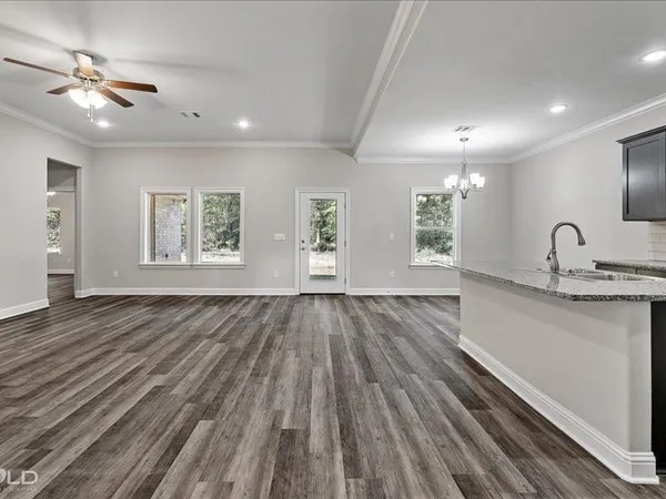 a view of an empty room and window and wooden floor