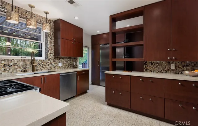 a kitchen with stainless steel appliances granite countertop a sink stove and cabinets