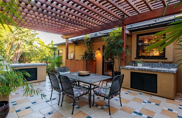 a patio with a table and chairs and potted plants