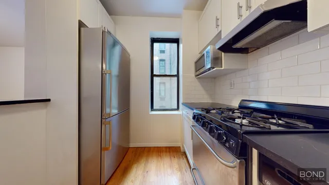 a kitchen with stainless steel appliances granite countertop a stove and a refrigerator