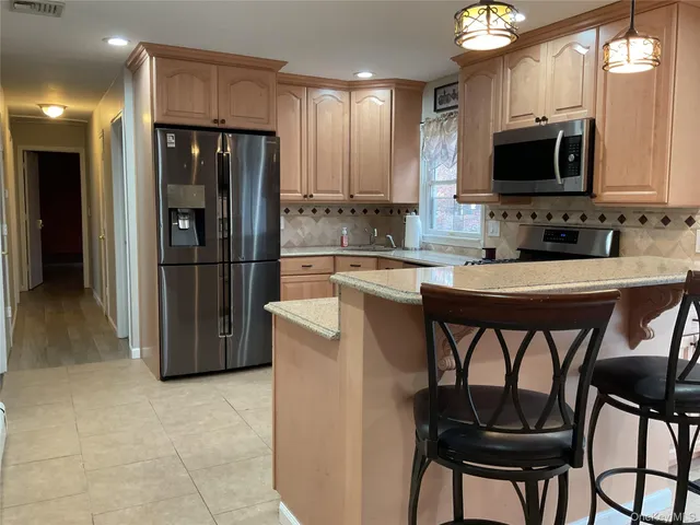 a kitchen with stainless steel appliances a refrigerator stove microwave and sink