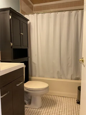 a bathroom with a toilet and a shower curtain