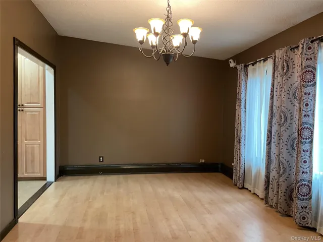 a view of a chandelier in big room with a chandelier fan