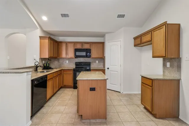 a kitchen with a stove top oven sink and cabinets