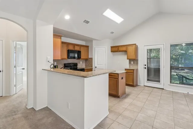 a kitchen with granite countertop a sink and steel appliances