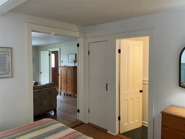 a view of a hallway with wooden floor and closet