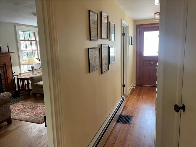 a view of a hallway with furniture and wooden floor