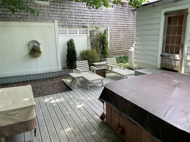a view of a patio with table and chairs with wooden floor and fence