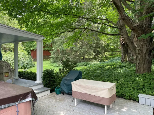 a patio with table and chairs and a large tree