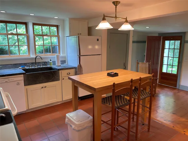 a kitchen with a wooden table and chairs